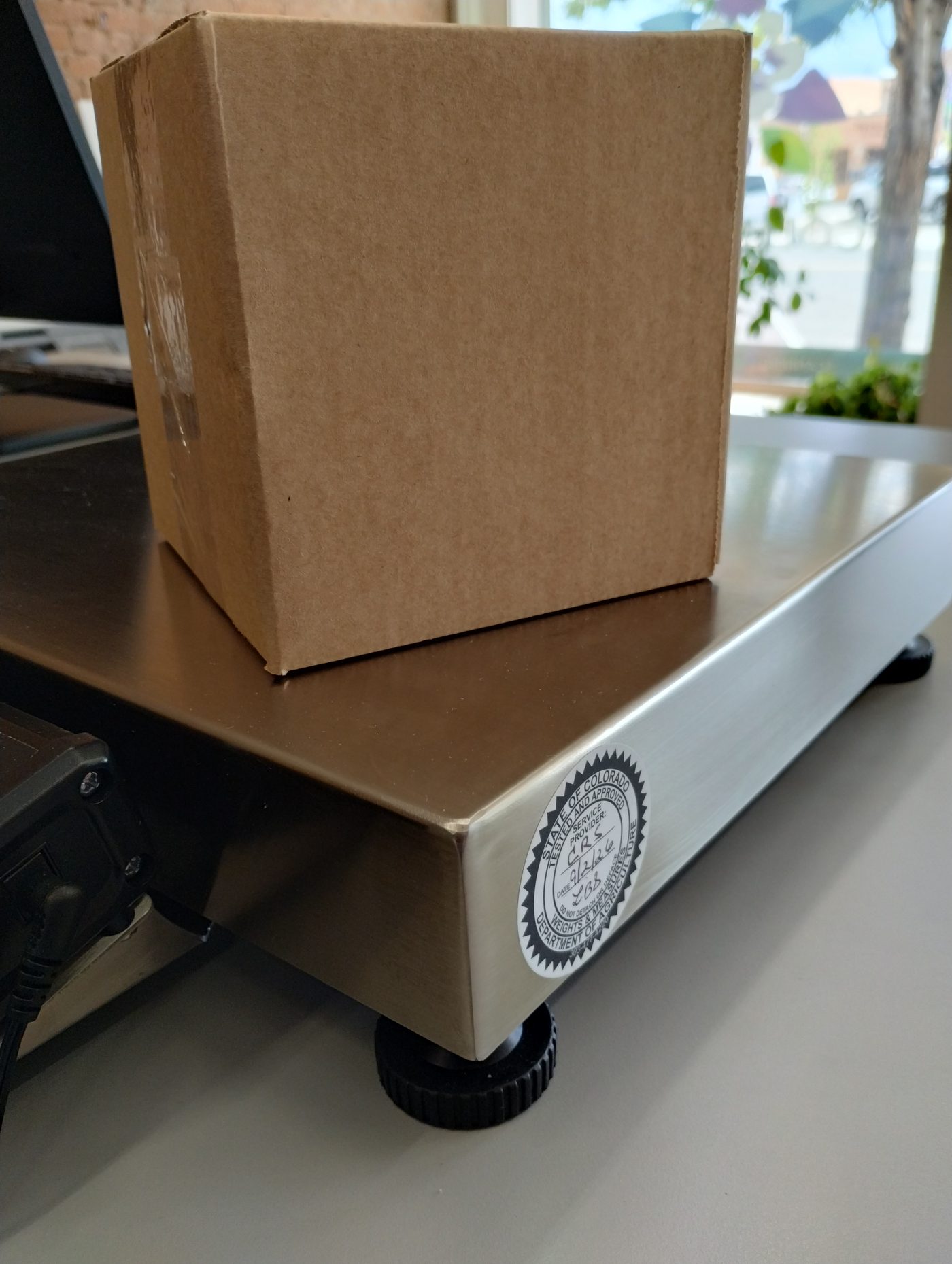 Package being weighed on a State of Colorado certified scale at Columbine Copy & Apparel